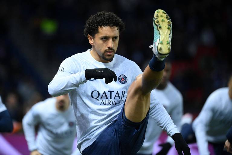 O zagueiro Marquinhos estica para o alto a perna esquerda em treino do Paris Saint-Germain
