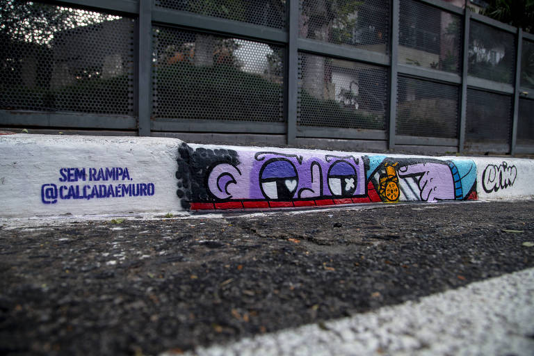 Em um meio-fio de uma calçada um grafite de um desenho animado bastante colorido; há a inscrição Sem Rampa, Calçada é Muro
