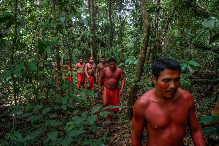 Indígenas amazônicos caminhando pela selva