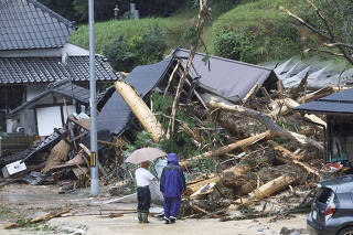 Local residents look at a landslide site caused by Typhoon Lan in Ayabe