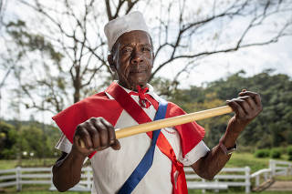 Especial Comunidade quilomba em Mocambique: Retrato do Sr Domingos Nunes,83, com bastao de madeira e roupa  caraterizada do grupo Mocambique Esperanca usada na apresentacao da danca Folguedo de Mocambique,  em area rual de Monteiro Lobato