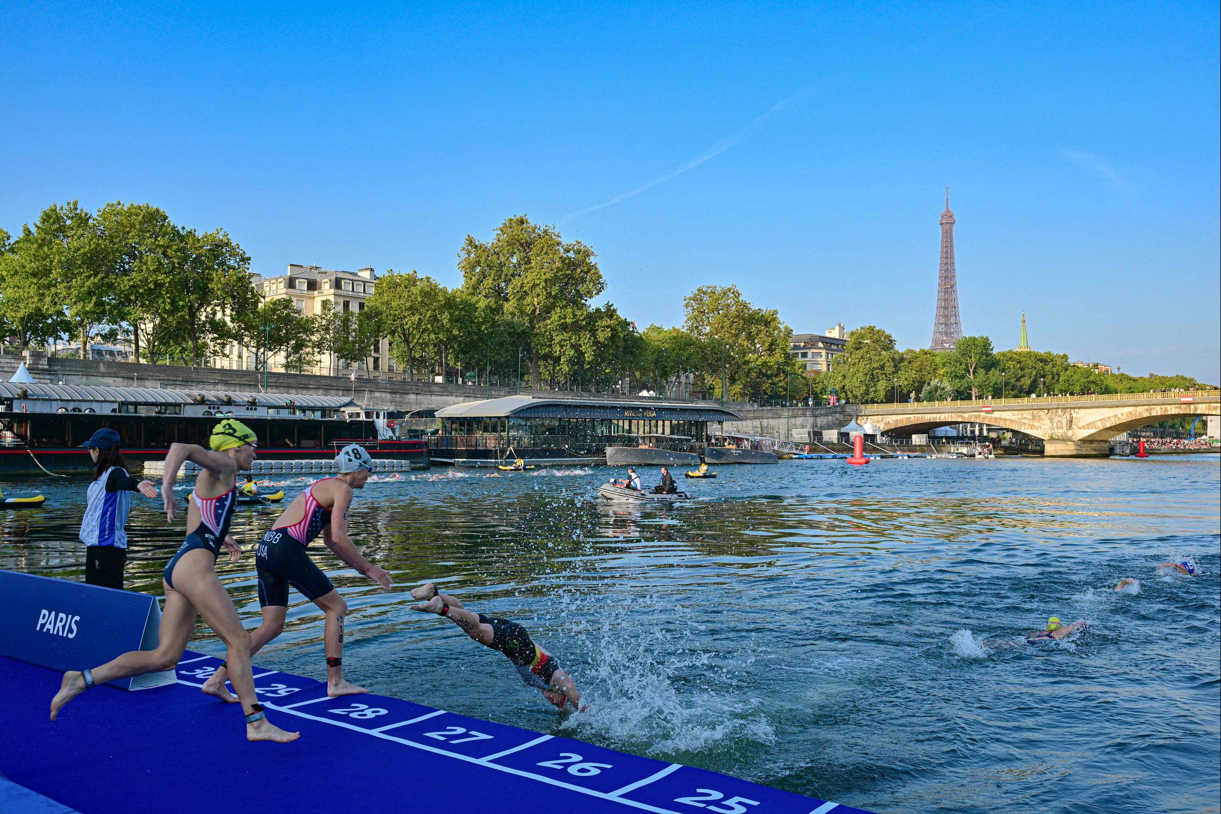 Triathlon athletes swim in the unpolluted Seine River in a test event for the 2024 Olympics
