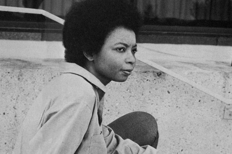 mulher negra jovem sentada em foto em preto e branco