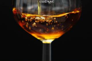 A technical expert pours Cognac in a cellar at the Hennessy factory in Cognac,