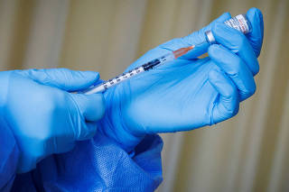 FILE PHOTO: A nurse prepares a vaccine shot as the German embassy begins its roll out of BioNTech COVID-19 vaccines for German expatriates at a Beijing United Family hospital in Beijing