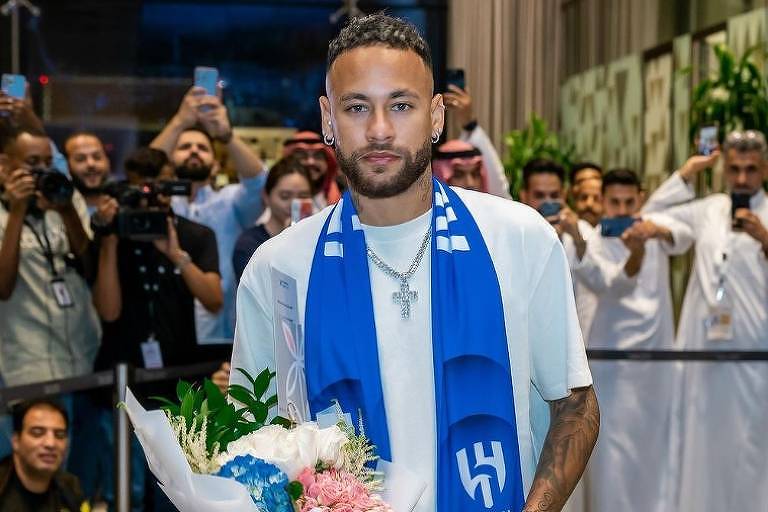 Em foto colorida, homem aparece com buquê de flores em aeroporto