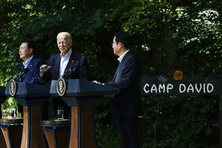 President Joe Biden speaking during a press briefing with South Korean President Yoon Suk Yeol, left, and Japanese Prime Minister Kishida Fumio at Camp David, outside of Thurmont, Md., Aug. 18, 2023. (Samuel Corum/The New York Times)