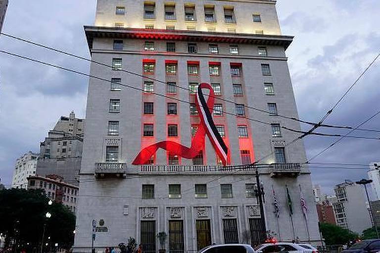 Grande laço nas cores preto, vermelho e branco estendido no prédio da prefeitura de São Paulo