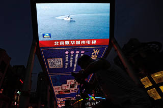 Screen broadcasts news footage of military drills by the Eastern Theatre Command of China's People's Liberation Army, in Beijing