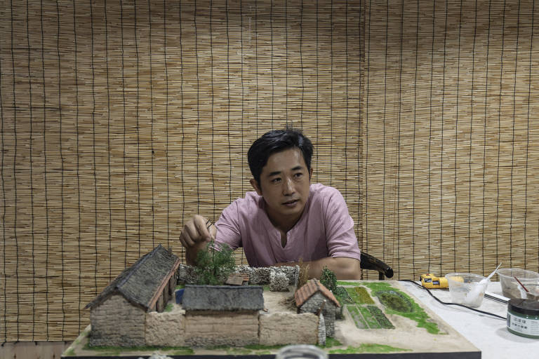Li Yizhong, um dos miniaturistas mais populares da China, com uma de suas maquetes, em seu estúdio em Jinan