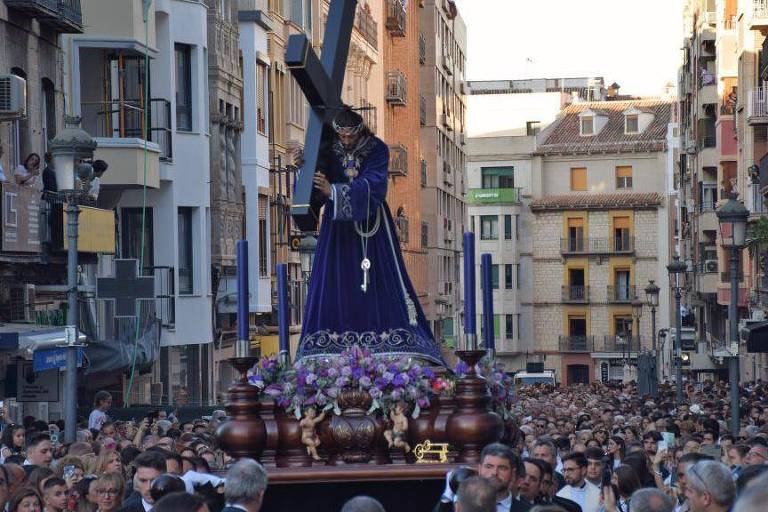 Imagem mostra multidão em procissão por uma rua na Espanha. Há uma escultura sendo carregada pelos fiéis.