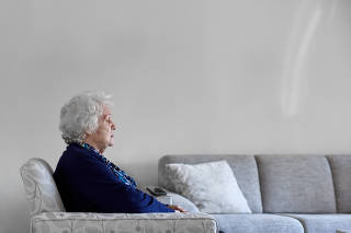 Elderly lady sitting on couch closing eyes