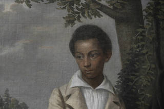Jeremy K. Simien, a Baton Rouge art collector, looks at the restored Bélizaire and the Frey Children, attributed to Jacques Amans, a 19th-century French portraitist of Louisianas elite. (Bron Moyi/The New York Times)