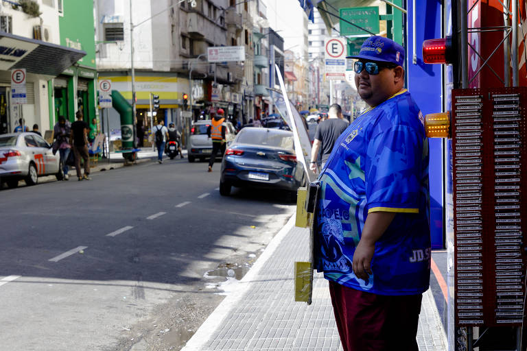 Puxadores tentam atrair clientes para lojas na rua Santa Ifigênia.