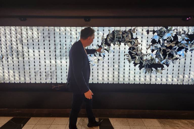 O artista britânico Dominic Harris diante de sua obra digital, instalada no cruzeiro Viva, da Norwegian Cruise Line