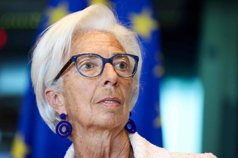 Presidente do Banco Central Europeu, Christine Lagarde, compareceu à audiência da Comissão de Assuntos Econômicos do Parlamento Europeu, em Bruxelas, Bélgica. Lagarde é uma mulher de cabelos brancos e curtos. Tem pele bronzeada e veste roupa branca e brincos azuis.