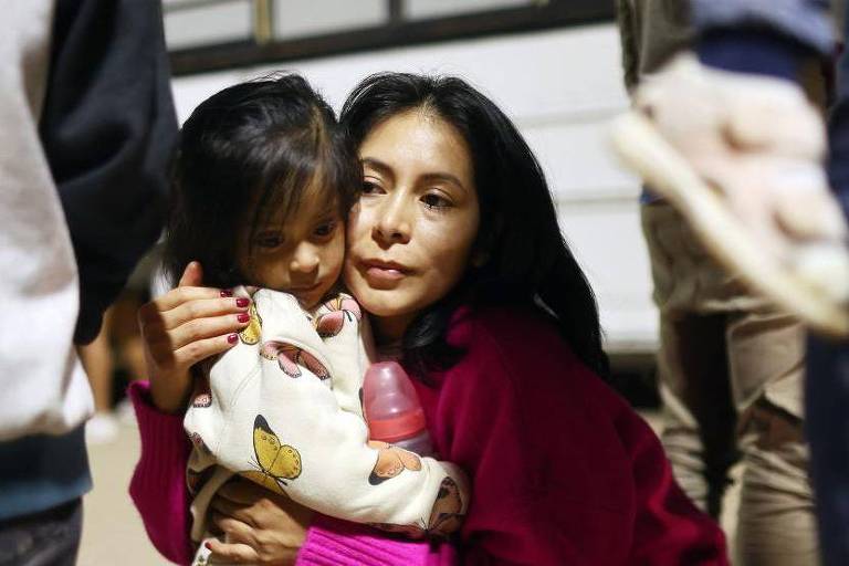 Mãe e filha esperam para cruzar fronteira dos EUA