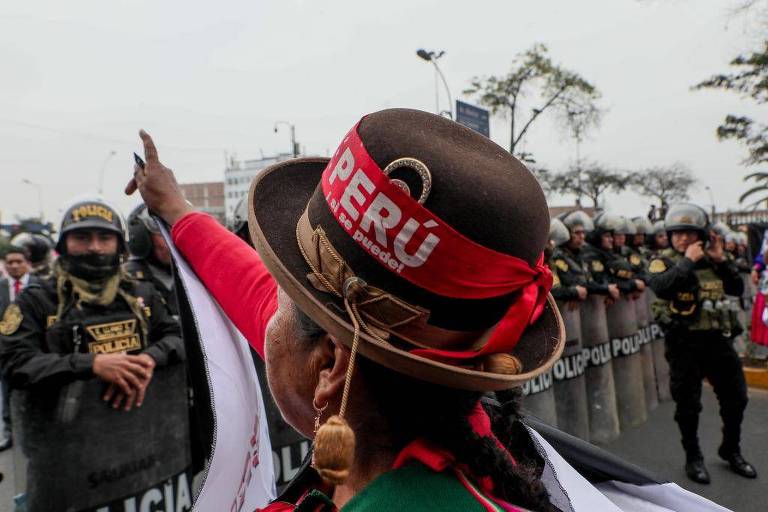 Mulher com chapéu e faixa com nome do Peru em protesto
