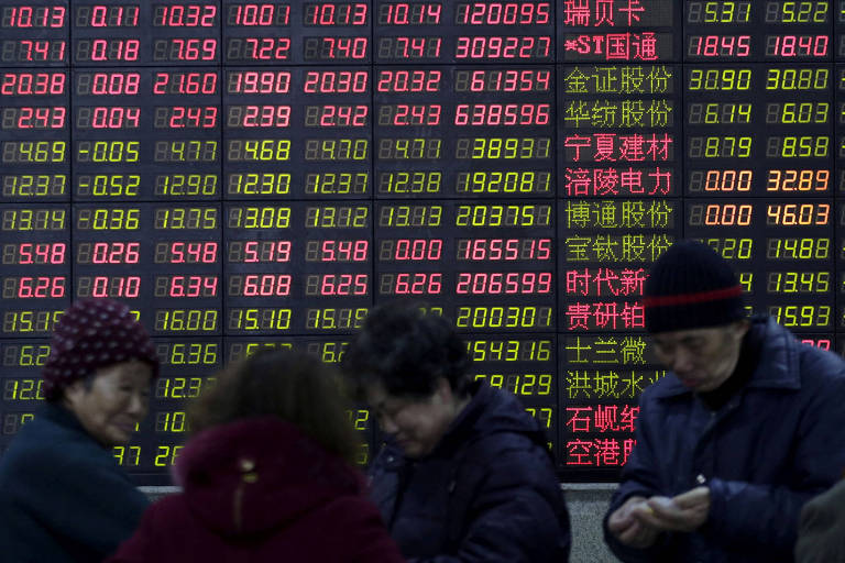 Investidores em frente a painel eletrônico da Bolsa em Xangai, China