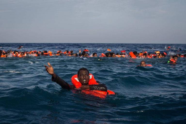 Migrantes no mar com coletes salva-vidas