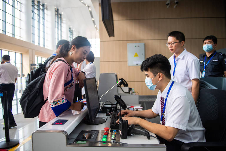 Passageira faz check-in em aeroporto na província de Hunan, na China