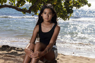 Kaliko Teruya, 13, is one of several young people suing Hawaii over its use of fossil fuels, at Honokowai Beach on Maui, Hawaii on Aug. 17, 2023. (Bryan Anselm/The New York Times)
