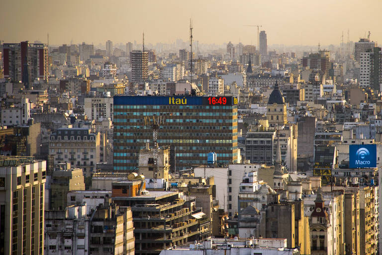 Letreiro do banco Itau no alto do edificio Torre Mirafiori, localizado na Avenida 9 de Julio , no bairro de San Nicolás da cidade de Buenos Aires. A direita, letreiro do banco Macro