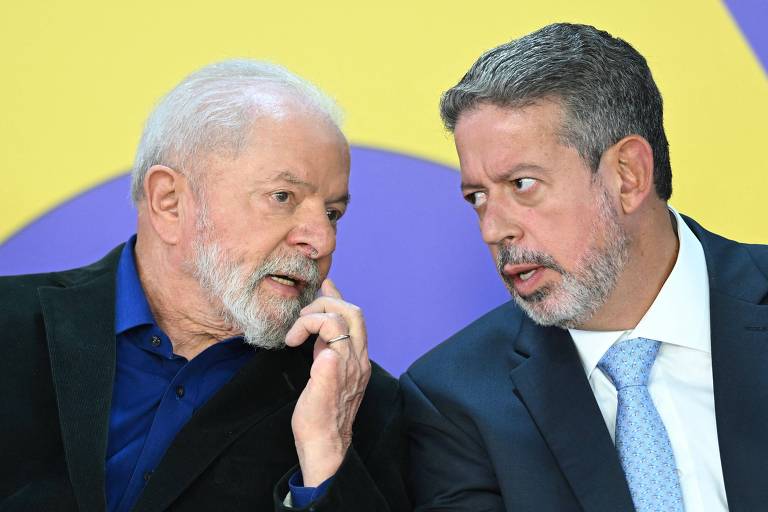 Fotografia colorida do presidente Lula, à esquerda, que conversa com o presidente da Câmara, Arthur Lira