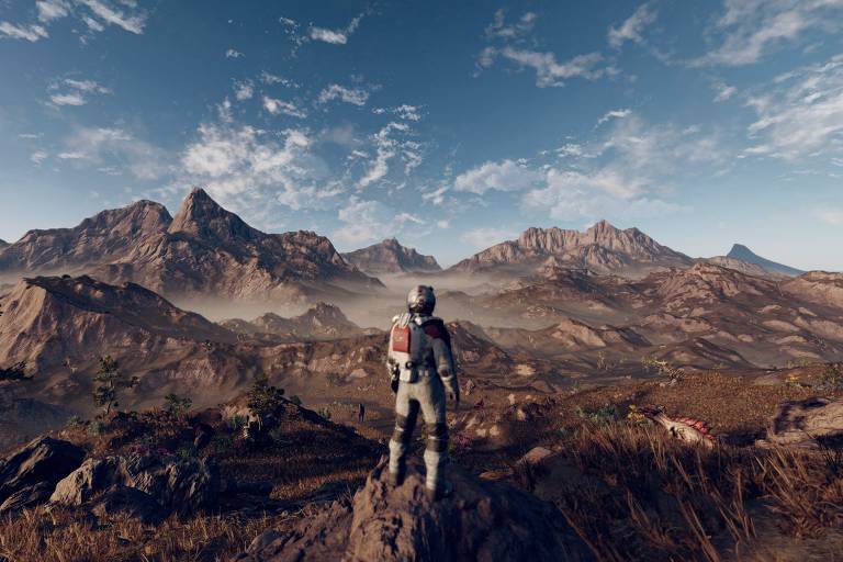 Imagem do videogame "Starfield" mostra pessoa em roupa de astronauta de pé em frente a uma paisagem montanhosa alienígena