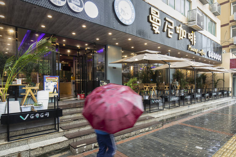 Cliente passa em frente ao Manny Coffee, que era de propriedade de Sun Junli, em Xianggang, na China