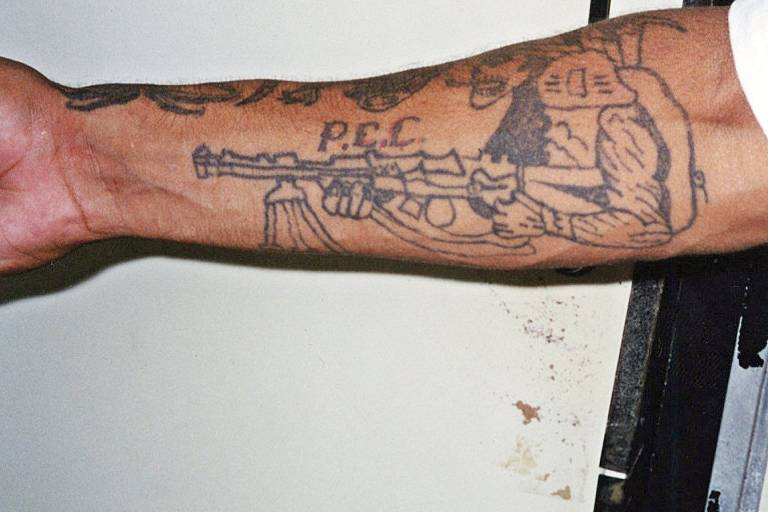 Braço direito do assaltante Aílton Lourenço Santana, suspeito de ser um dos fundadores do PCC, com as iniciais do comando tatuadas