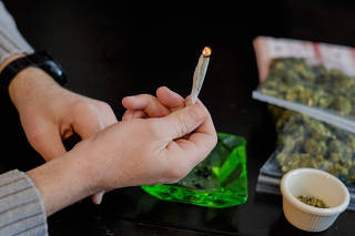 A marijuana decriminalization advocate holds a lit joint at a news conference in Washington, Feb. 26, 2015. (T.J. Kirkpatrick/The New York Times)