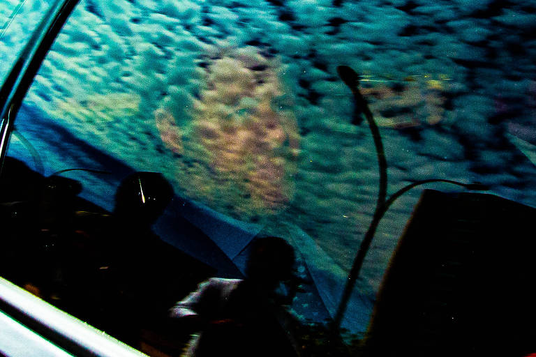 Imagem de homem é vista através de vidro escurecido de carro