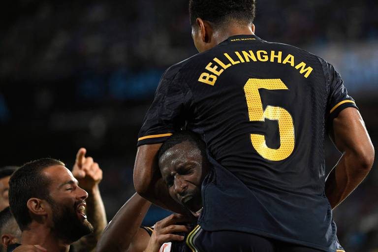 Bellingham, vestindo a camisa 5 do Real Madrid, salta sobre o companheiro Rüdiger em comemoração de gol no Campeonato Espanhol