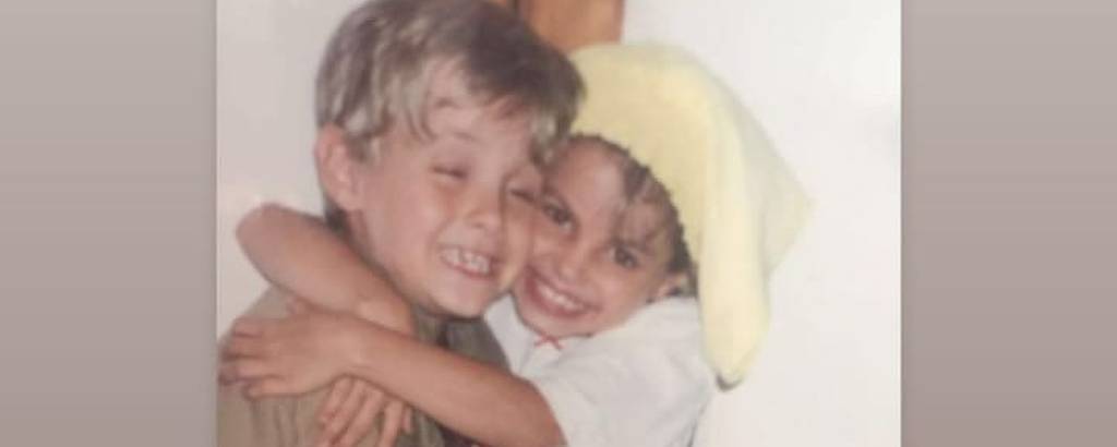 Imagem mostra Kayky Brito e a irmã, a atriz Styhefany Brito, abraçados quando ainda crianças. Kayky e a irmã expressam sorriso. 