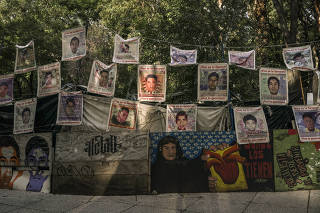 Posters of some of the 43 students who, in what is perhaps the country?s most notorious cold case, were kidnapped by police and turned over to a cartel, along Reforma Avenue in Mexico City on Aug. 15, 2023. (Luis Antonio Rojas/The New York Times)
