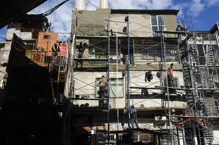 Pedreiros de cooperativas locais contratadas pelo governo reformam fachada das casas na Villa 31, em processo de urbanização da favela