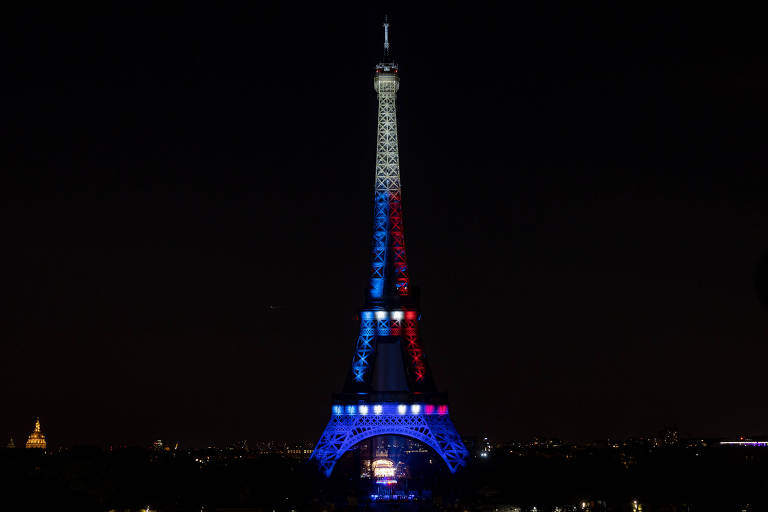 Torre Eiffel iluminada com as cores da bandeira da França  --branco, azul e vermelho