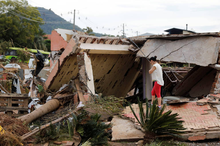Pessoa olha para escombros na cidade de Roca Sales, no Rio Grande do Sul