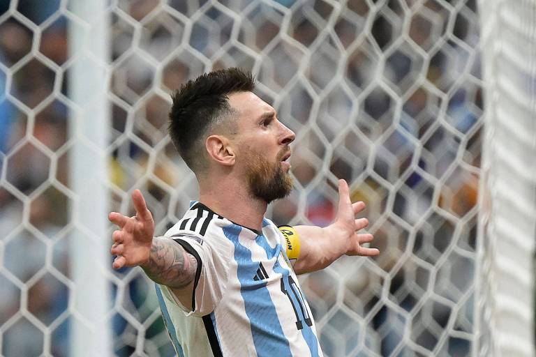 Com os braços abertos e olhando para a torcida, Messi comemora depois de marcar de pênalti o segundo gol da Argentina diante da Holanda nas quartas de final da Copa de 2022, em Lusail, no Qatar 