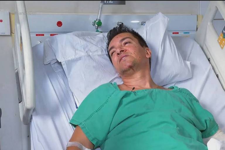 Em foto colorida, homem se recupera no leito de um hospital