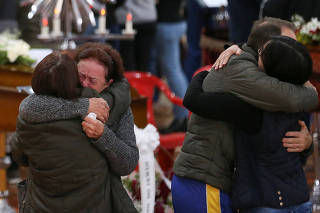 People mourn victims during a wake ceremony, after an extratropical cyclone hit southern cities, in Vespasiano Correa