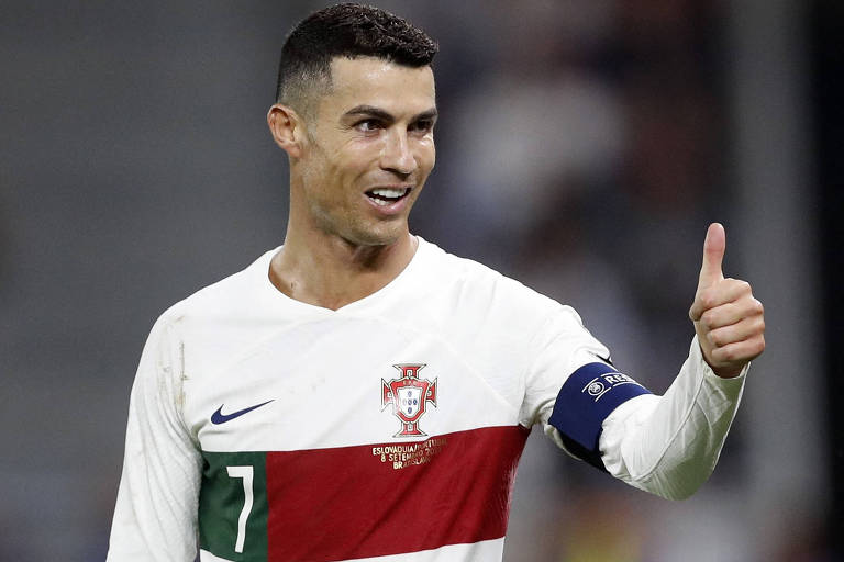 Cristiano Ronaldo, vestindo a camisa com o número e usando a tarja de capitão no braço esquerdo, faz sinal de positivo com a mão esquerda em partida de Portugal contra a Eslováquia em Bratislava  