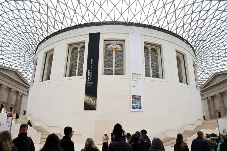 No inferior da imagem, é possível ver as silhuetas de vários visitantes. Em cima, há o interior do museu.