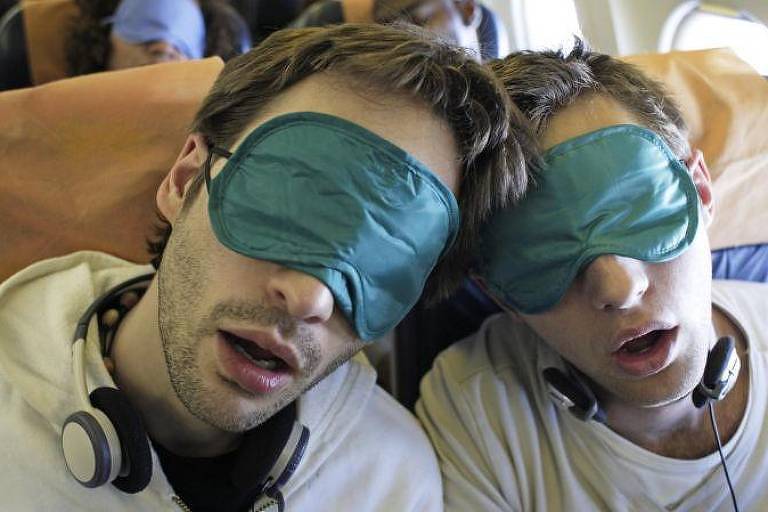 Passageiros de avião dormindo com proteção nos olhos