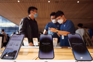 FILE PHOTO: A customer talks to sales assistants in an Apple store as Apple Inc's new iPhone 14 models go on sale in Beijing