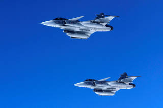 Swedish Air Force Saab JAS 39 Gripen fighter jets fly alongside an aircraft simulating aerial interceptions during a media day