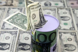 FILE PHOTO: Dollar banknotes are seen under Euro saving money box in this picture illustration