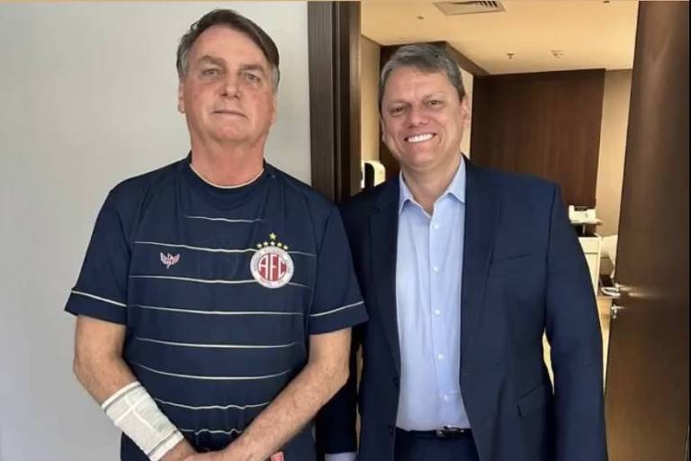 Tarcísio e Bolsonaro, dois homens brancos, posam para foto.
