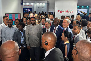 Guyana's president Irfaan Ali and Exxon's Guyana country chief Alistair Routledge smile for a picture at Guyana's International Energy Conference in Georgetown